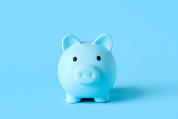 Blue piggy bank on color background