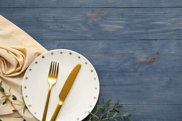 Beautiful table setting with eucalyptus branches on blue wooden background