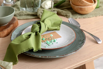 Elegant table setting with beautiful flowers and folded napkin in restaurant, closeup