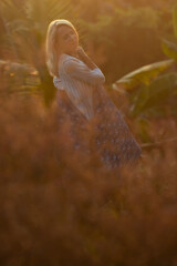 Beautiful mature woman in blue dress at sunset, natural elegance and anti-aging concep