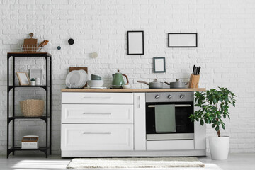 Interior of kitchen with shelf unit, counter and utensils