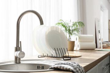 Sink with plates on counter near window in kitchen