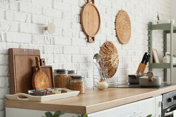 Cutting boards with food on counter near white brick wall in kitchen