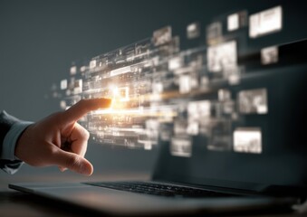 A hand interacts with a holographic digital interface streaming from a laptop, showcasing data flow and technological interaction