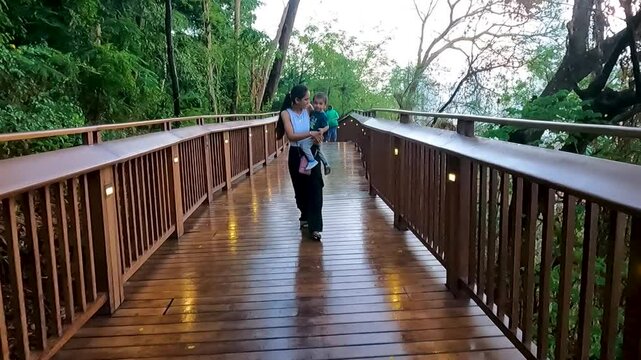 Video of a mother at Mumbai's skywalk along with her toddler. Nature trail, malabar hill, tourism, tourist, tickets, booking, online, wooden, gallery, view, sea, marine.