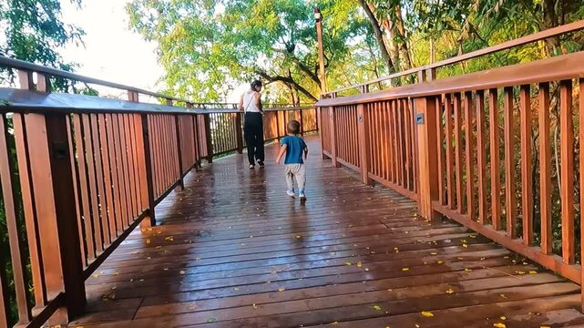 Video of a mother at Mumbai's skywalk along with her toddler. Nature trail, malabar hill, tourism, tourist, tickets, booking, online, wooden, gallery, view, sea, marine.