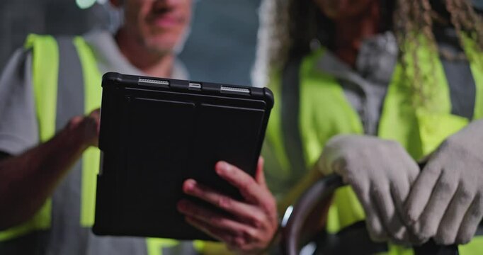 Closeup on hands. Engineer holding a tablet giving instructions to warehouse staff.