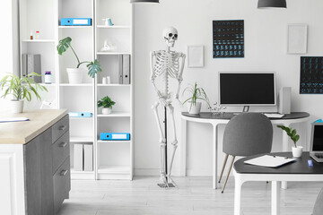 Interior of light hospital with human skeleton model, x-ray images and modern computer