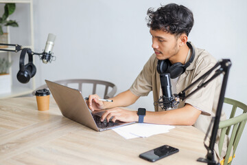 Young Journalist Man Using Mic and Laptop, Conducts a Broadcast Remotely from Home