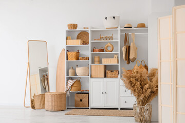 Interior of light room with closet, baskets and mirror
