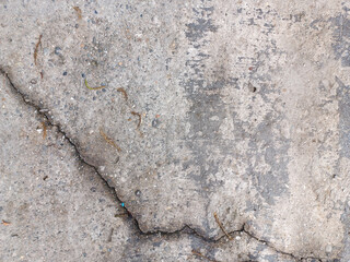 A close-up of a cracked concrete wall, showcasing a prominent diagonal crack running across the...