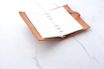 Opened schedule planner, diary, notebook on white table
