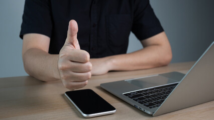 Businessman hand showing finger gesture thumb up sign, recommendation or good job choice. Professional multicultural team recommend corporate service.