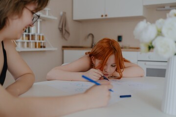 A 13-year-old teenage girl and her mother are drawing and playing together. They enjoy creative...