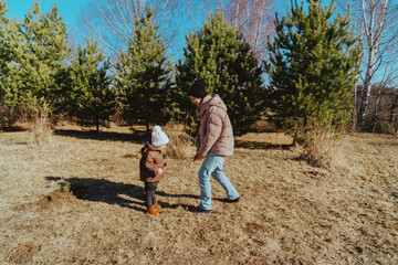 A mother and her 3-year-old daughter walk together in the park, enjoying nature and quality family time. A heartwarming moment of love, care, and happiness as they explore the outdoors together