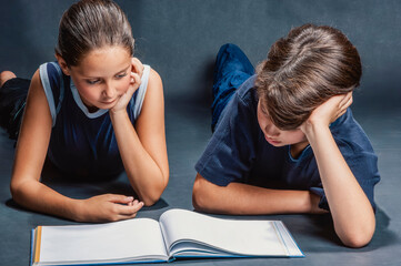Two elementary school students reading a book together