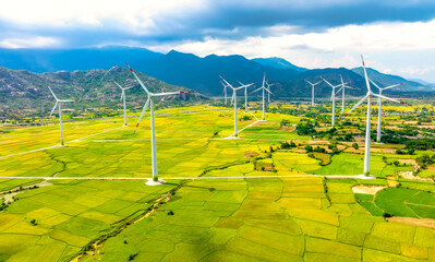 Panoramic view of wind farm or wind park. Wind turbines generating electricity on rice field at Phan Rang, Ninh Thuan, Vietnam. Clean energy concept