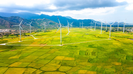 Panoramic view of wind farm or wind park. Wind turbines generating electricity on rice field at Phan Rang, Ninh Thuan, Vietnam. Clean energy concept