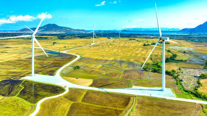 Panoramic view of wind farm or wind park. Wind turbines generating electricity on rice field at Phan Rang, Ninh Thuan, Vietnam. Clean energy concept