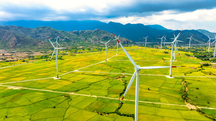 Panoramic view of wind farm or wind park. Wind turbines generating electricity on rice field at Phan Rang, Ninh Thuan, Vietnam. Clean energy concept