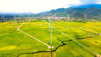 Panoramic view of wind farm or wind park. Wind turbines generating electricity on rice field at Phan Rang, Ninh Thuan, Vietnam. Clean energy concept