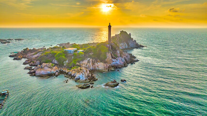 Landscape of small island with ancient lighthouse at sunrise sky is beautiful and peaceful. This is only ancient lighthouse is located on island in Vietnam