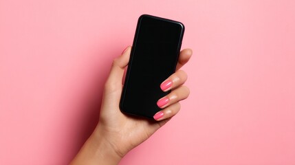hand holding a smartphone on pink background