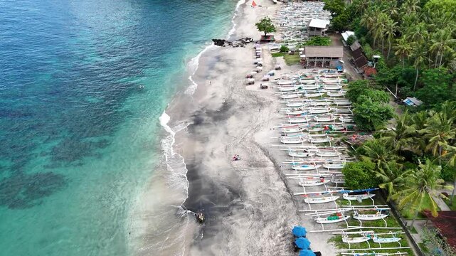 View from above the aerial drone of the white sand virgin beach and coconut forest with a real time view of the blue sea sky