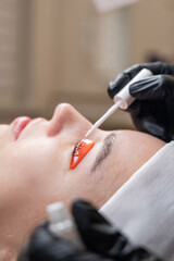 Caucasian woman undergoing eyelash lamination procedure. 