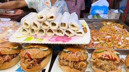 Burgers drizzled with sauces and wrapped shawarma rolls form a delicious food display together