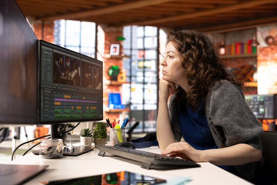 Female filmmaker editing montage and video clips with creative software, creating media content in post production. Agency workspace features movie making modern tools, cinematic industry.