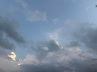 The light blue sky is partially obscured by dense, ominous gray clouds