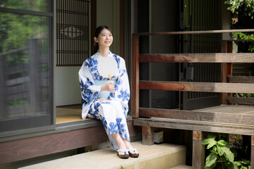 Woman in yukata relaxing on the porch of an old house Looking up at the view Image
