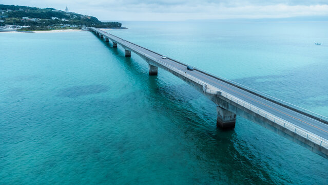 A Long bridge of Kouri Island and beach from a high view by drone with clear sky and sea water.