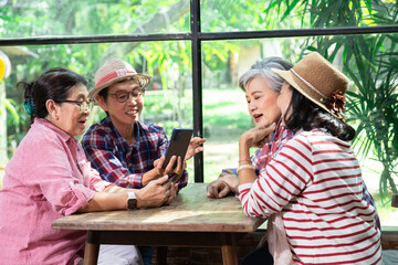 Group elderly mature business owner friends meeting in eatery restaurant using phone selfie take photo together, senior pension female happy free time celebation holiday, wellness aging care lifestyle