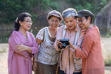 Group of Asian retirement women travelling, hiking, walking togehter in park, senior pensioner friends spend time exercise trekking in forest, unrecognizable elderly tourist lifestyle one day trip