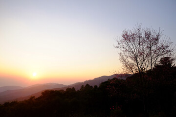 Beautiful landscape of dramatic sky with sunrise shining over the silhouette valley mountain in Thailand