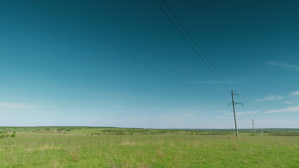 A beautiful scenic rural landscape adorned with power lines extending under a clear sky