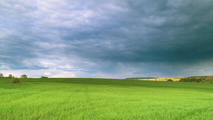 Obraz premium The Serene Green Fields Lie Under a Dramatic and Beautiful Cloudy Sky Above Them Time lapse.
