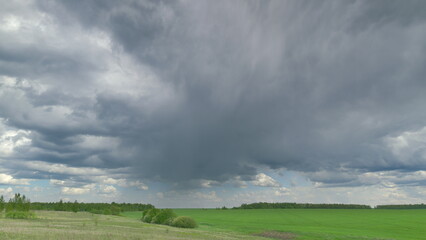 Dramatic Cloud Formation Towering Over Lush Green Fields Stretching Across the Horizon Time lapse.