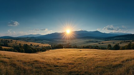 Obraz premium Golden sunlight illuminates a tranquil mountain valley.