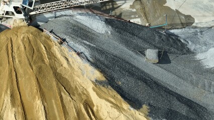 Aerial shot linking the cement plant with nearby construction sites via truck routes, showcasing its role in local infrastructure projects.
