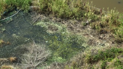 Drone view captures soil degradation and discoloration caused by industrial pollutants, with toxic...