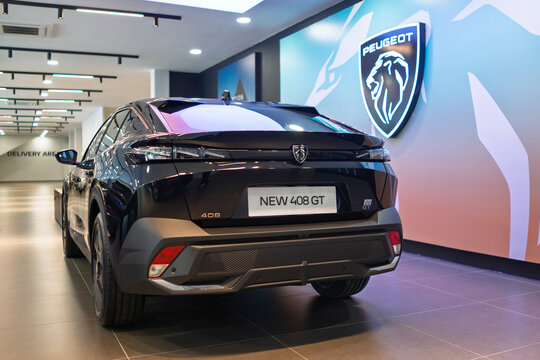 Penang, Malaysia &ndash; May 16, 2025: Rear view of the Peugeot 408 GT in a showroom setting, showcasing its bold design, illuminated logo, and sleek tail light details against a gradient wall background.