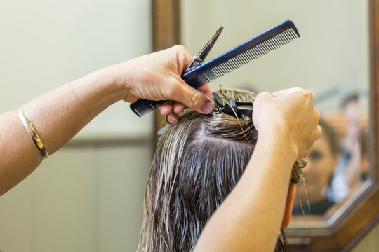 Close up of a hairdresser clipping a ladies hair into position