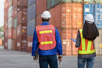Engineer and foreman dock worker inspecting containers box at shipping yard, Inspectors at container yard inspecting cargo