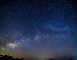 Naklejka premium Stunning night sky with the Milky Way galaxy visible above the horizon. Perfect for astronomy, space, and nature projects.