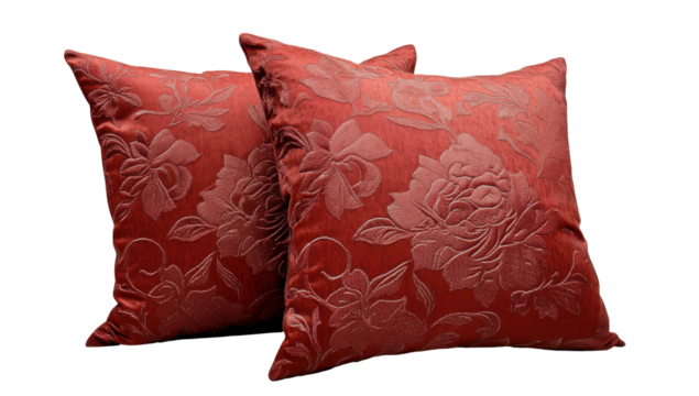 Two rust-colored square cushions with an embossed floral pattern, showcasing a textured fabric and slightly overlapping placement