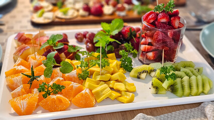 Various fruits are beautifully arranged on a plate. Healthy food is ready to eat.