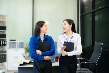 Two Asian businesswoman and man discuss investment project working and planning strategy